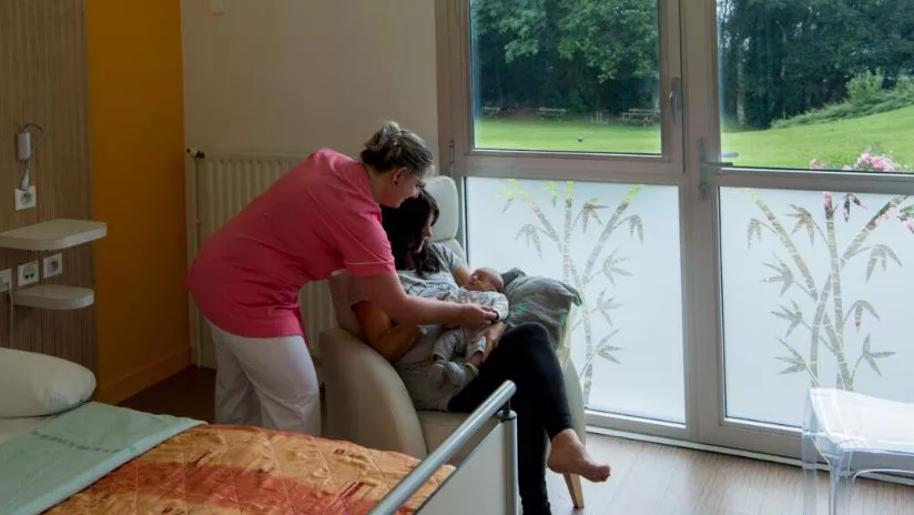 femme avec son bébé et un soignante